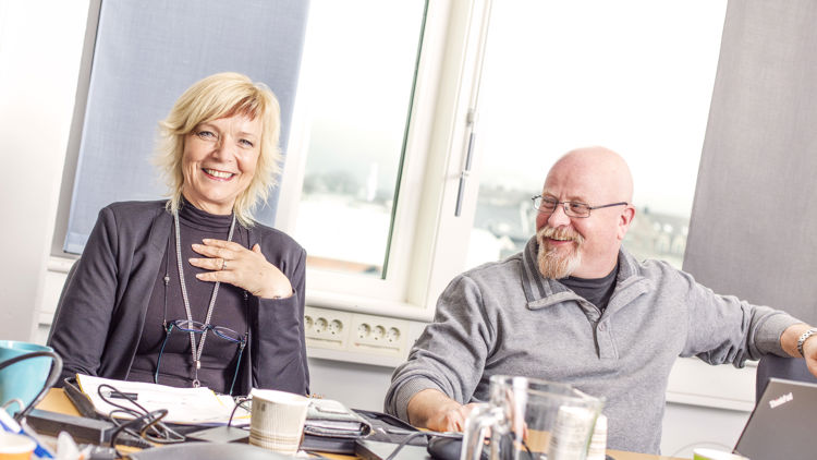 Illustrasjonsbilde som viser to kollegaer som ler sammen på jobb